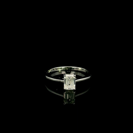 18K white gold solitaire ring featuring a 0.90 carat IGI certified natural emerald cut diamond with VS2 clarity and D colour in a classic four-prong setting.