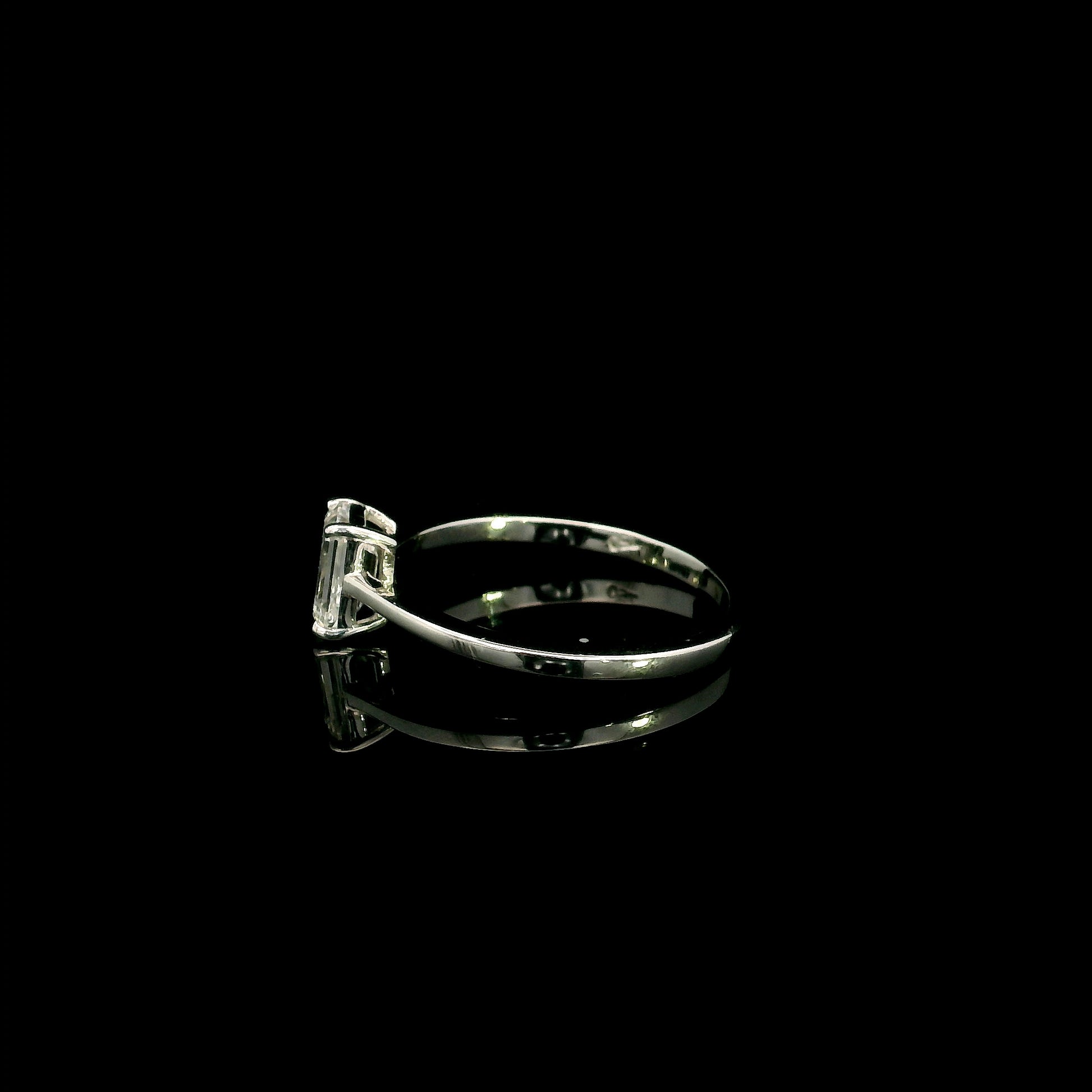 18K white gold solitaire ring featuring a 0.90 carat IGI certified natural emerald cut diamond with VS2 clarity and D colour in a classic four-prong setting.
