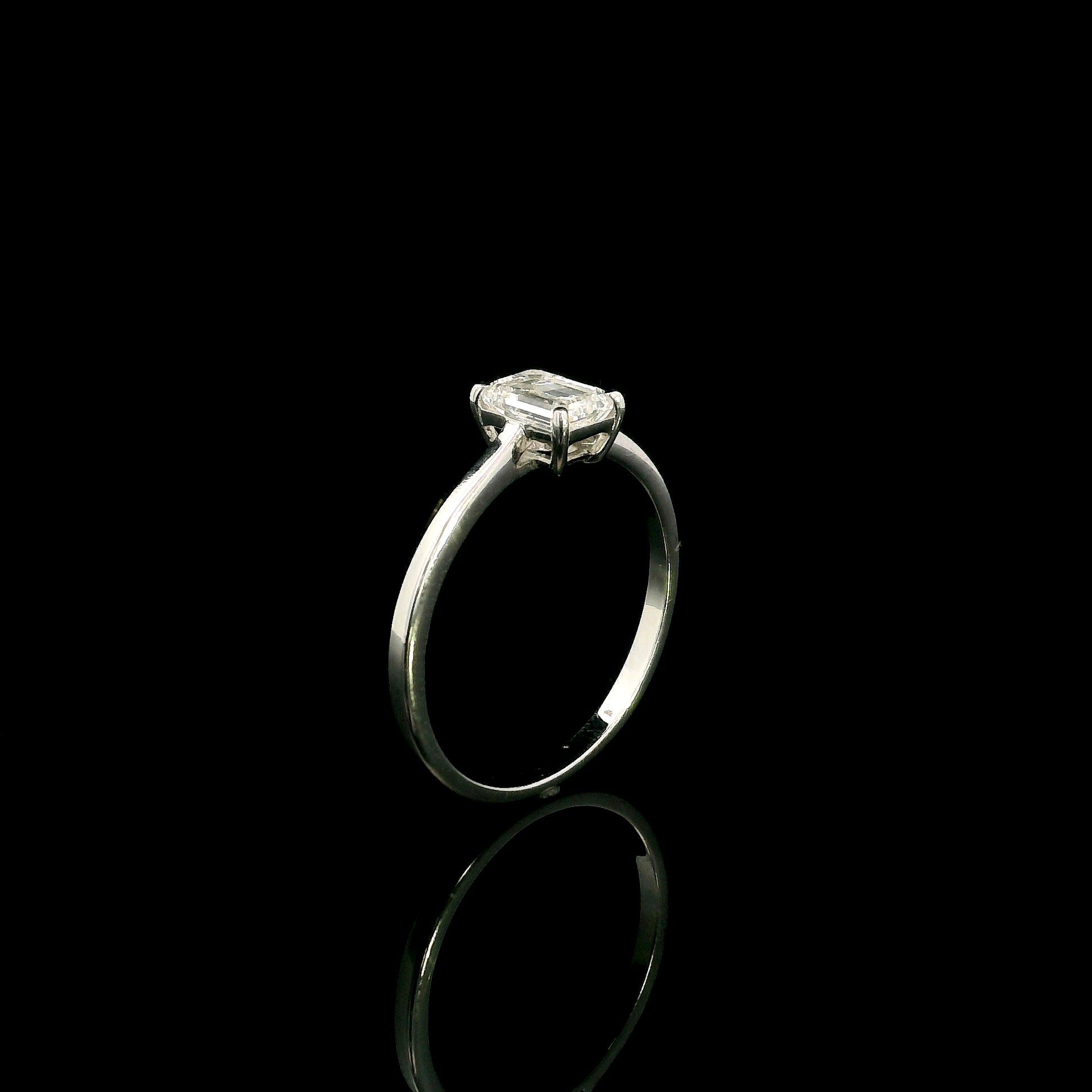 18K white gold solitaire ring featuring a 0.90 carat IGI certified natural emerald cut diamond with VS2 clarity and D colour in a classic four-prong setting.