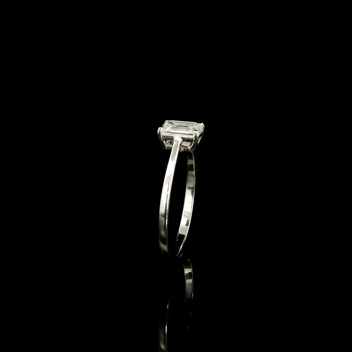 18K white gold solitaire ring featuring a 0.90 carat IGI certified natural emerald cut diamond with VS2 clarity and D colour in a classic four-prong setting.