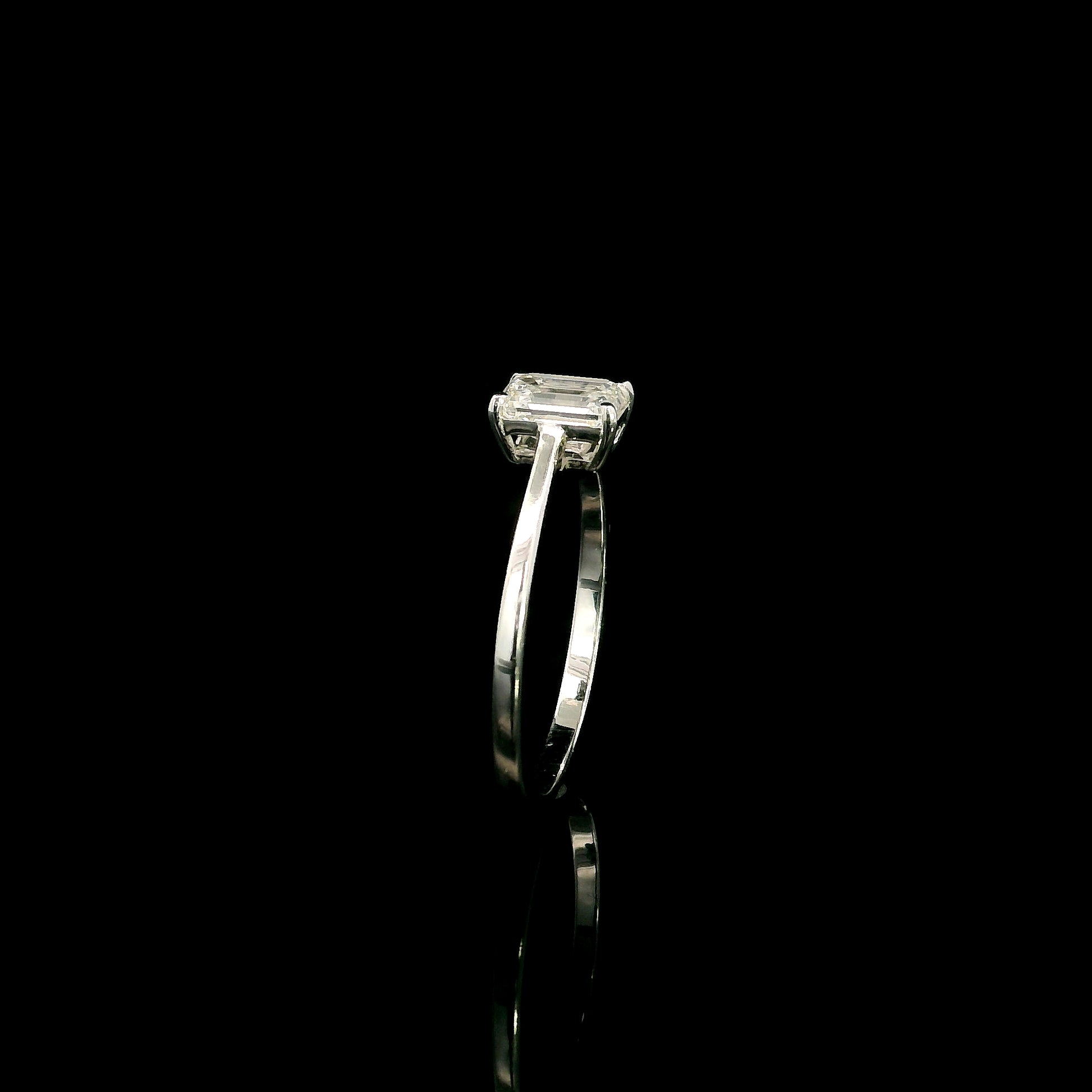 18K white gold solitaire ring featuring a 0.90 carat IGI certified natural emerald cut diamond with VS2 clarity and D colour in a classic four-prong setting.