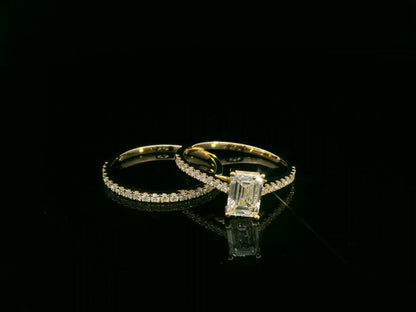 Emerald-cut diamond engagement ring and pavé wedding band bridal set in 18K yellow gold – Emirates Diamonds.