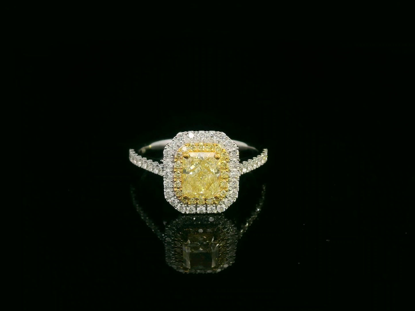 18K white gold fancy yellow radiant-cut diamond ring with yellow inner halo and white diamond outer halo by Emirates Diamonds.