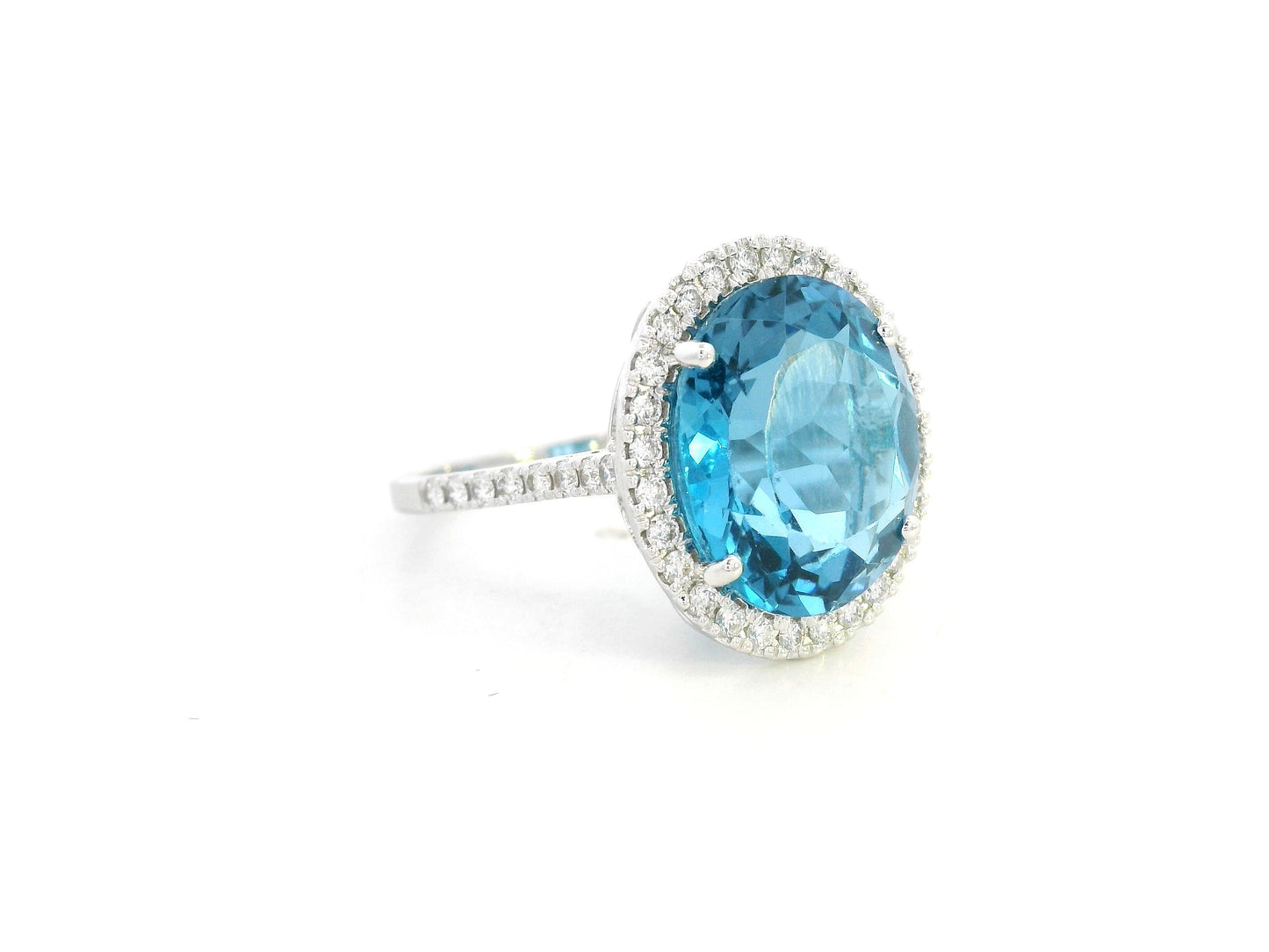 18K white gold ring with 9.15-carat oval London Blue Topaz and double diamond halo – Emirates Diamonds.