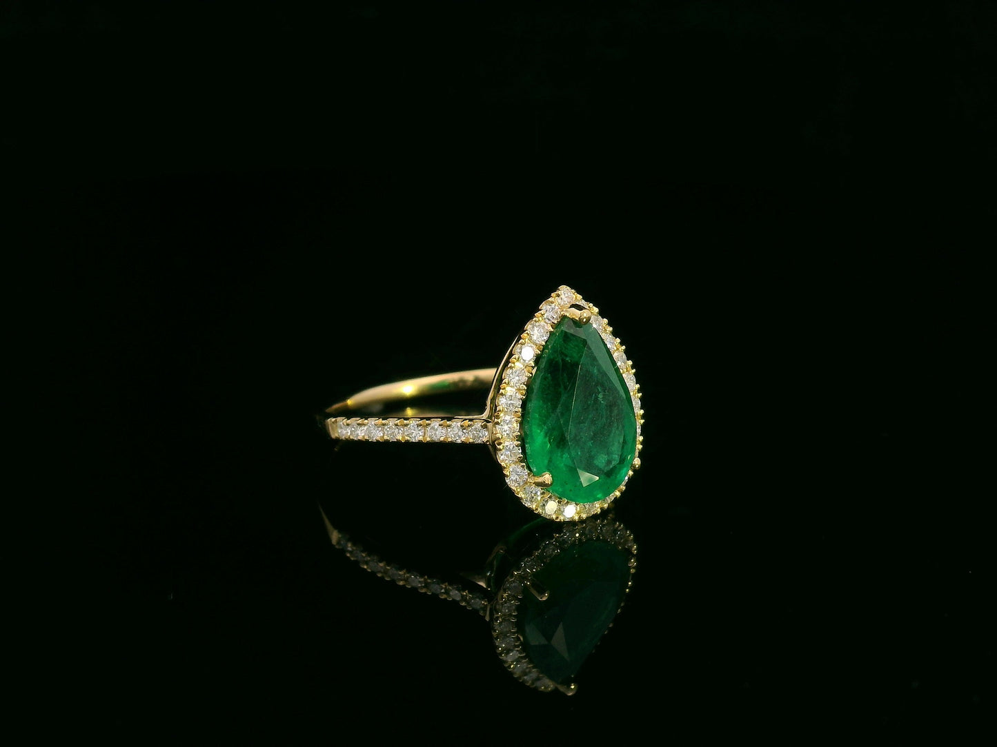 18K yellow gold pear-shaped emerald and diamond halo ring with 2.69 carat emerald and 0.40 carat total diamond weight by Emirates Diamonds