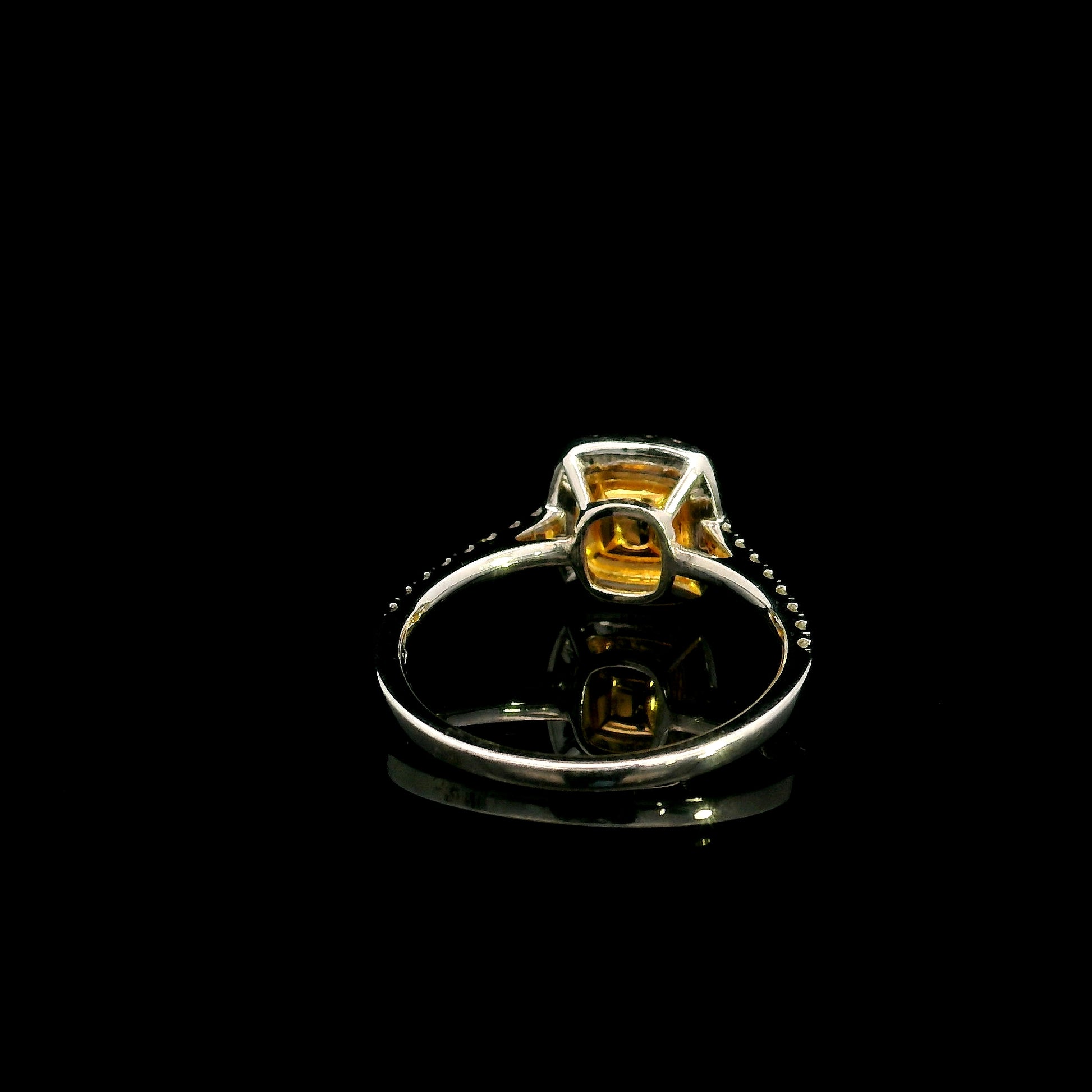 18K white gold engagement ring featuring a 0.58 carat GIA certified Fancy Yellow cushion cut diamond with SI1 clarity, surrounded by yellow and white diamond double halos with a diamond-set band.