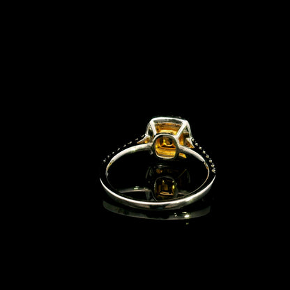 18K white gold engagement ring featuring a 0.58 carat GIA certified Fancy Yellow cushion cut diamond with SI1 clarity, surrounded by yellow and white diamond double halos with a diamond-set band.