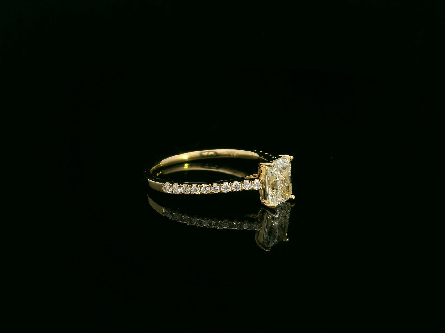 18K yellow gold radiant-cut diamond solitaire ring with pavé diamond band, 0.90 carat IGI certified center diamond and 0.21 carat accent diamonds by Emirates Diamonds