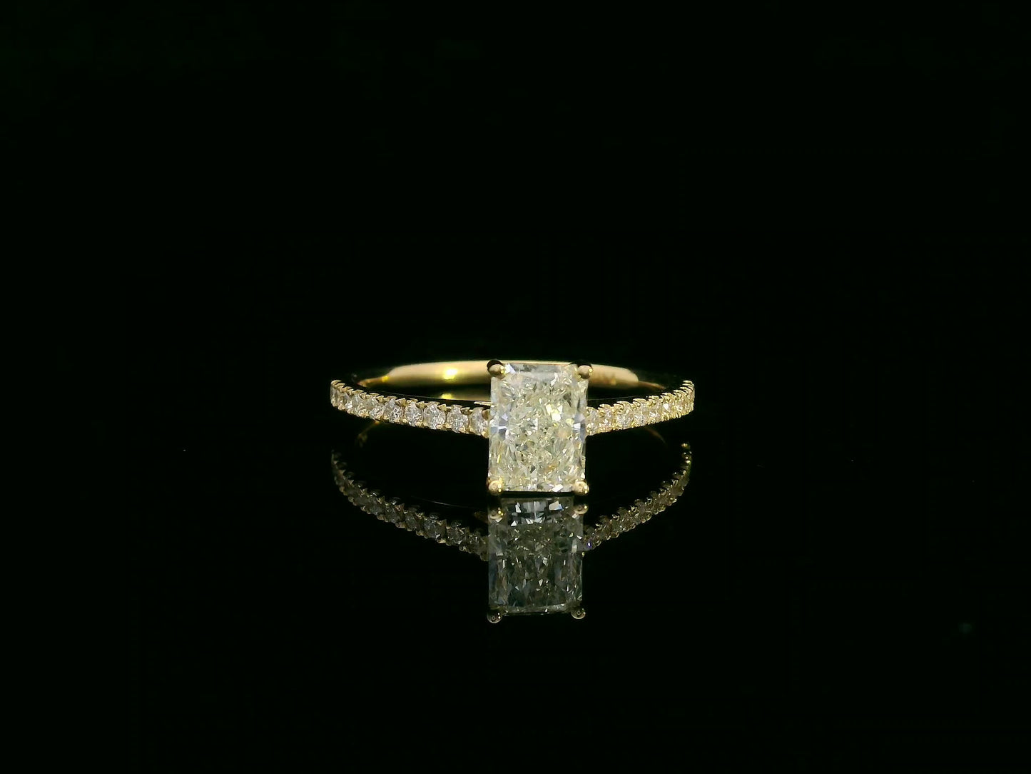 18K yellow gold radiant-cut diamond solitaire ring with pavé diamond band, 0.90 carat IGI certified center diamond and 0.21 carat accent diamonds by Emirates Diamonds