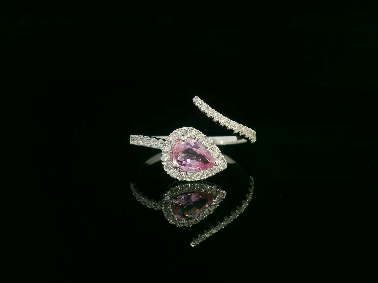 18K white gold pear-shaped pink sapphire and diamond bypass ring with halo design by Emirates Diamonds