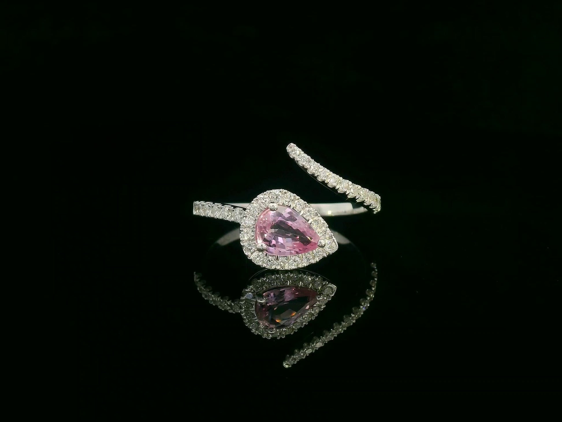 18K white gold pear-shaped pink sapphire and diamond bypass ring with halo design by Emirates Diamonds