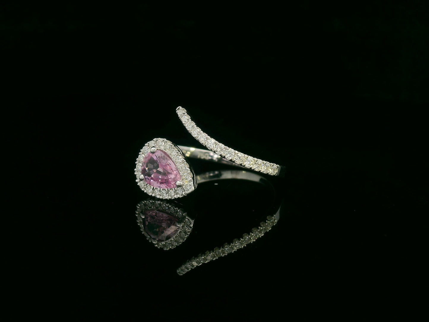 18K white gold pear-shaped pink sapphire and diamond bypass ring with halo design by Emirates Diamonds