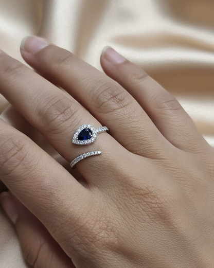 18K white gold bypass ring with pear-shaped blue sapphire and diamond halo by Emirates Diamonds