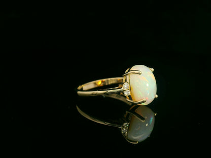 18K yellow gold opal and diamond ring featuring a 2.60 carat oval opal with diamond accents by Emirates Diamonds