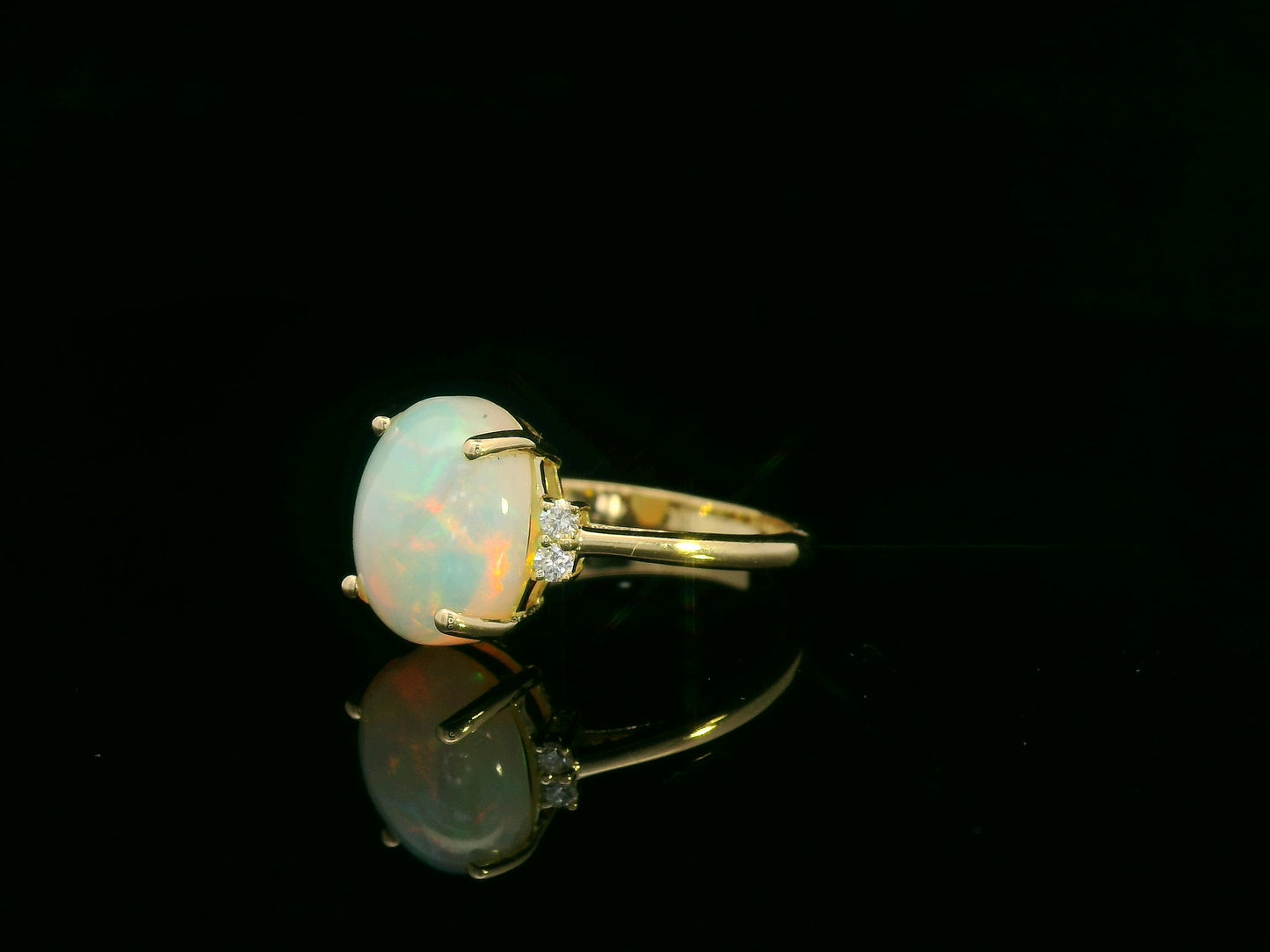 18K yellow gold opal and diamond ring featuring a 2.60 carat oval opal with diamond accents by Emirates Diamonds