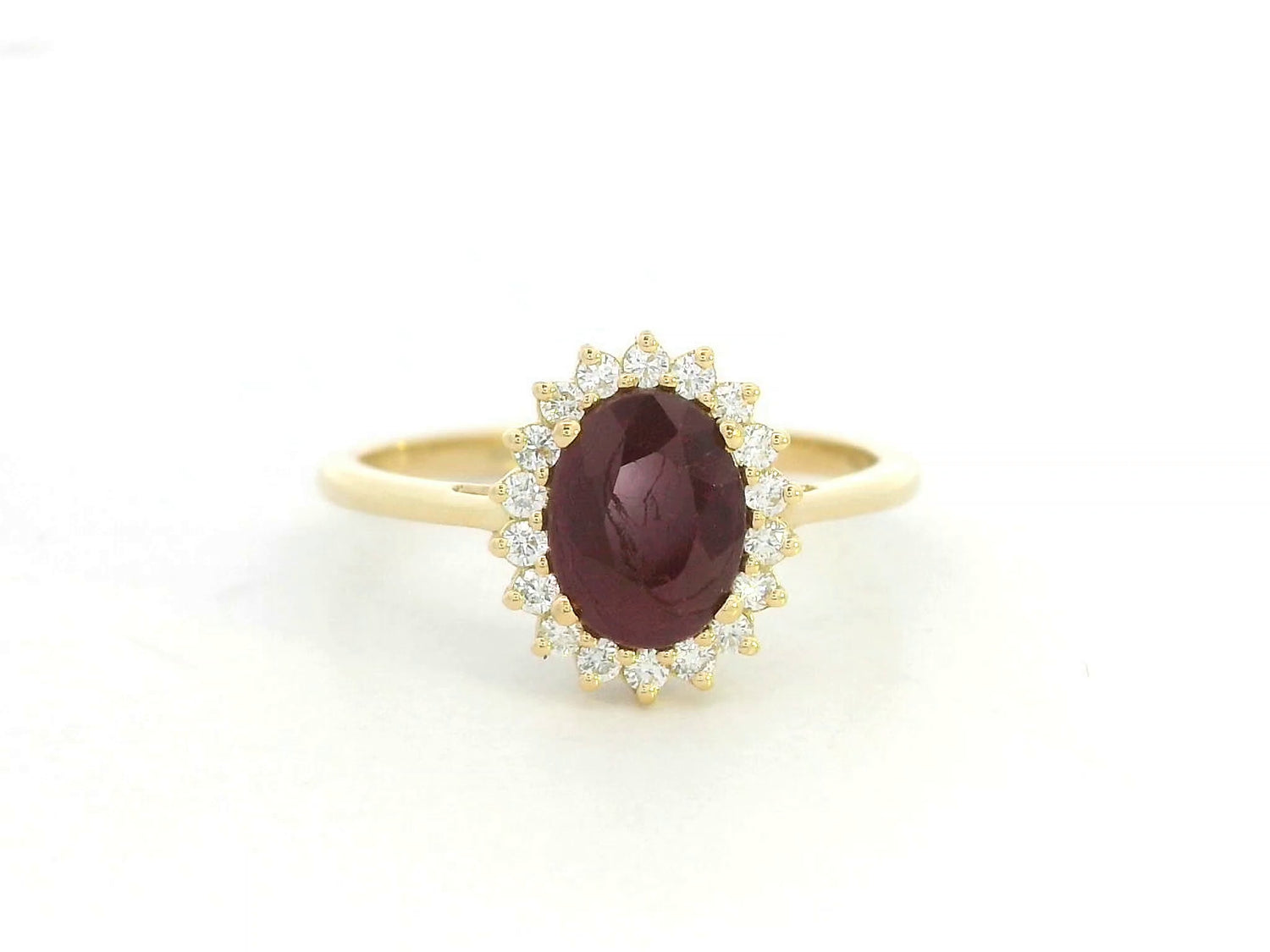 18K yellow gold ruby and diamond halo ring featuring a 1.28 carat oval ruby and 0.19 carat natural diamonds by Emirates Diamonds