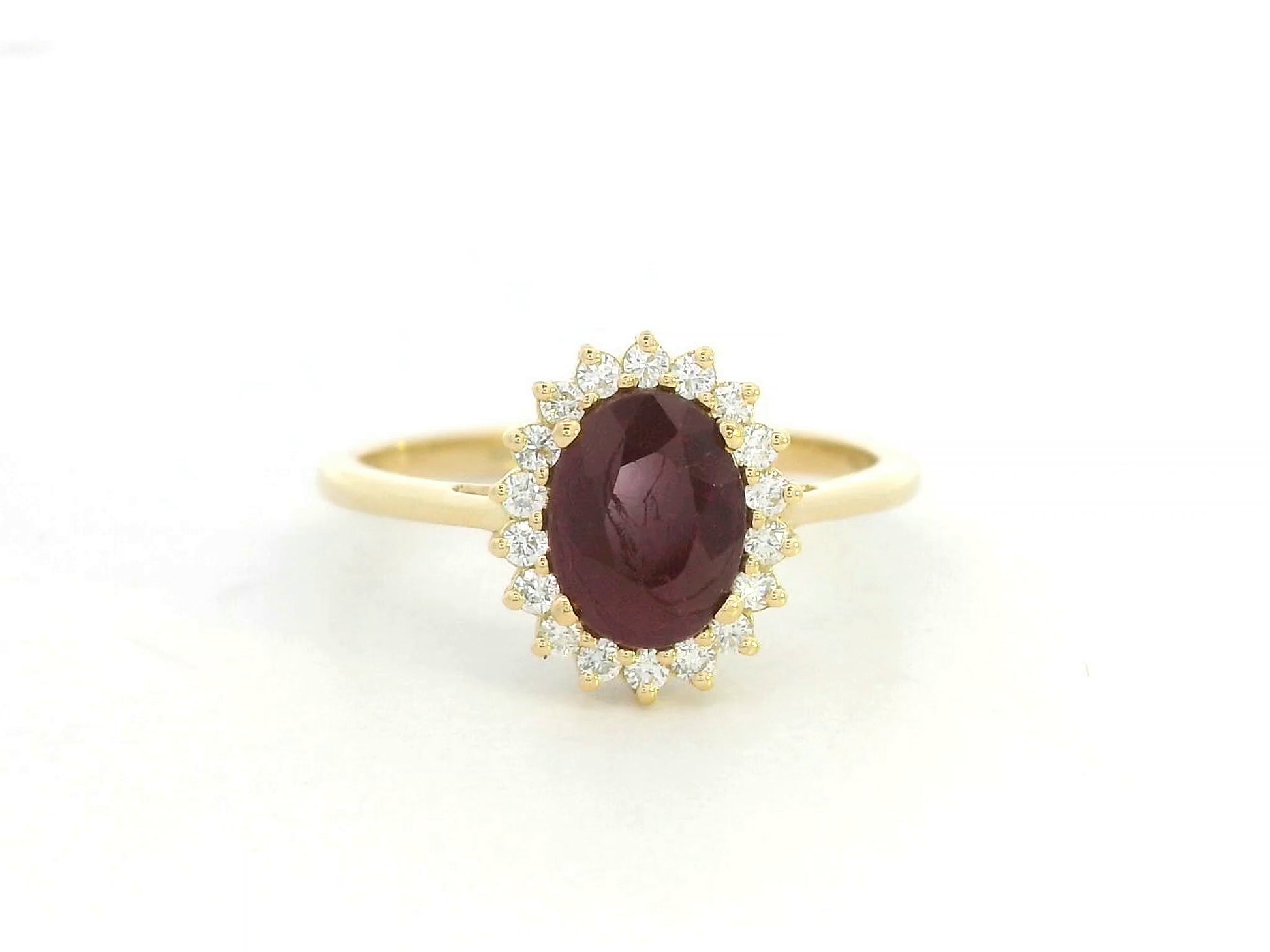18K yellow gold ruby and diamond halo ring featuring a 1.28 carat oval ruby and 0.19 carat natural diamonds by Emirates Diamonds