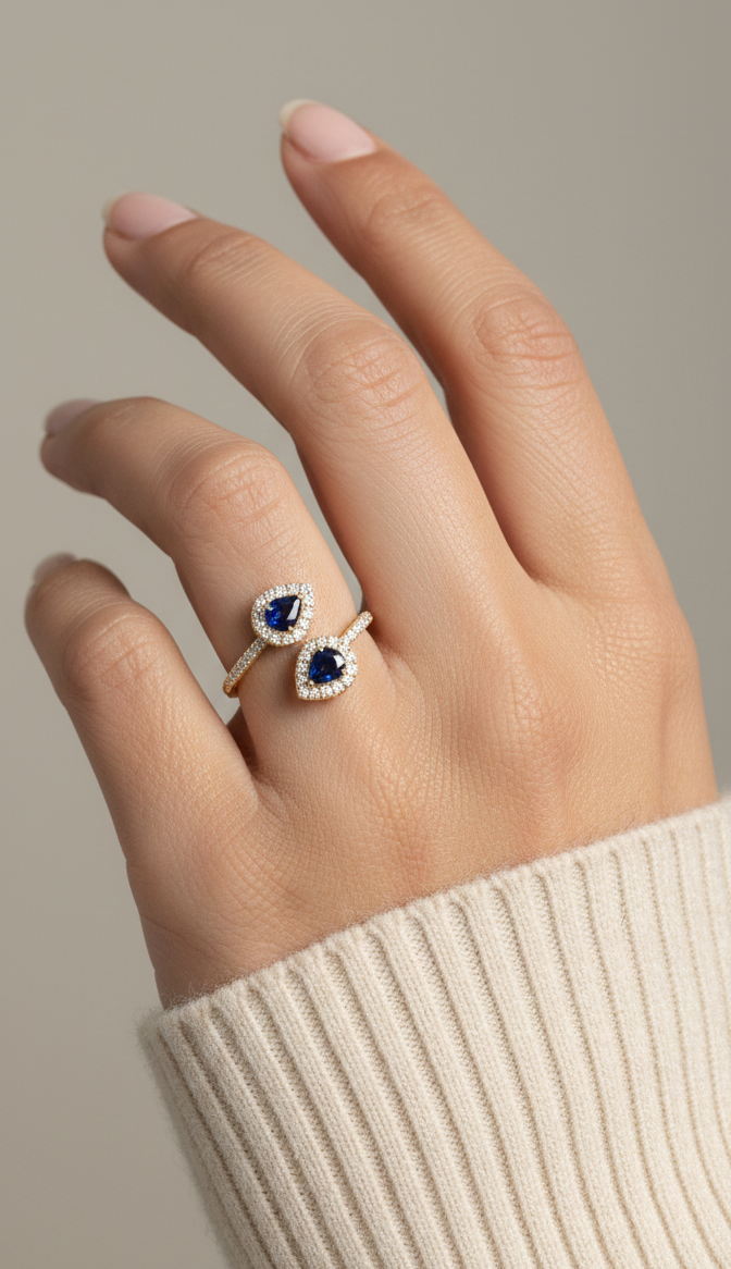 Blue sapphire and diamond Toi-et-Moi ring in 18K yellow gold with pear-shaped sapphires and diamond halo by Emirates Diamonds