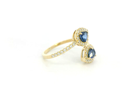 Blue sapphire and diamond Toi-et-Moi ring in 18K yellow gold with pear-shaped sapphires and diamond halo by Emirates Diamonds