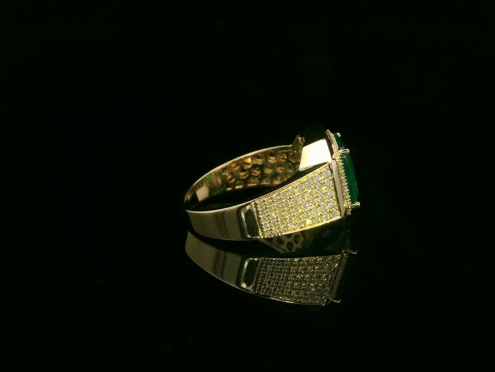 Men’s 18K yellow gold emerald and diamond statement ring featuring a 3.30 carat emerald with diamond halo and wide pavé band by Emirates Diamonds