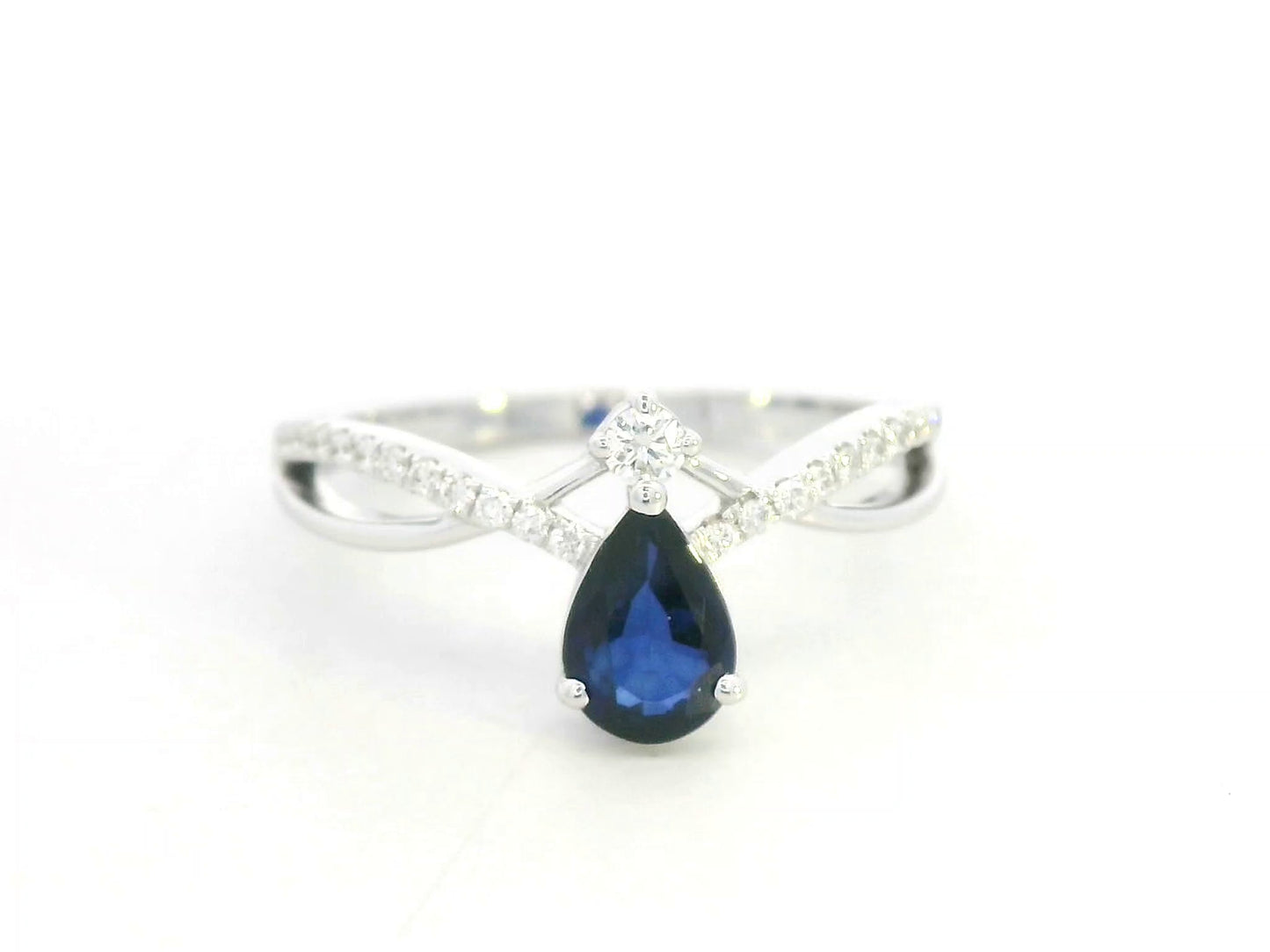 18K white gold blue sapphire and diamond crossover band ring, pear-shaped sapphire with pavé diamond accents by Emirates Diamonds