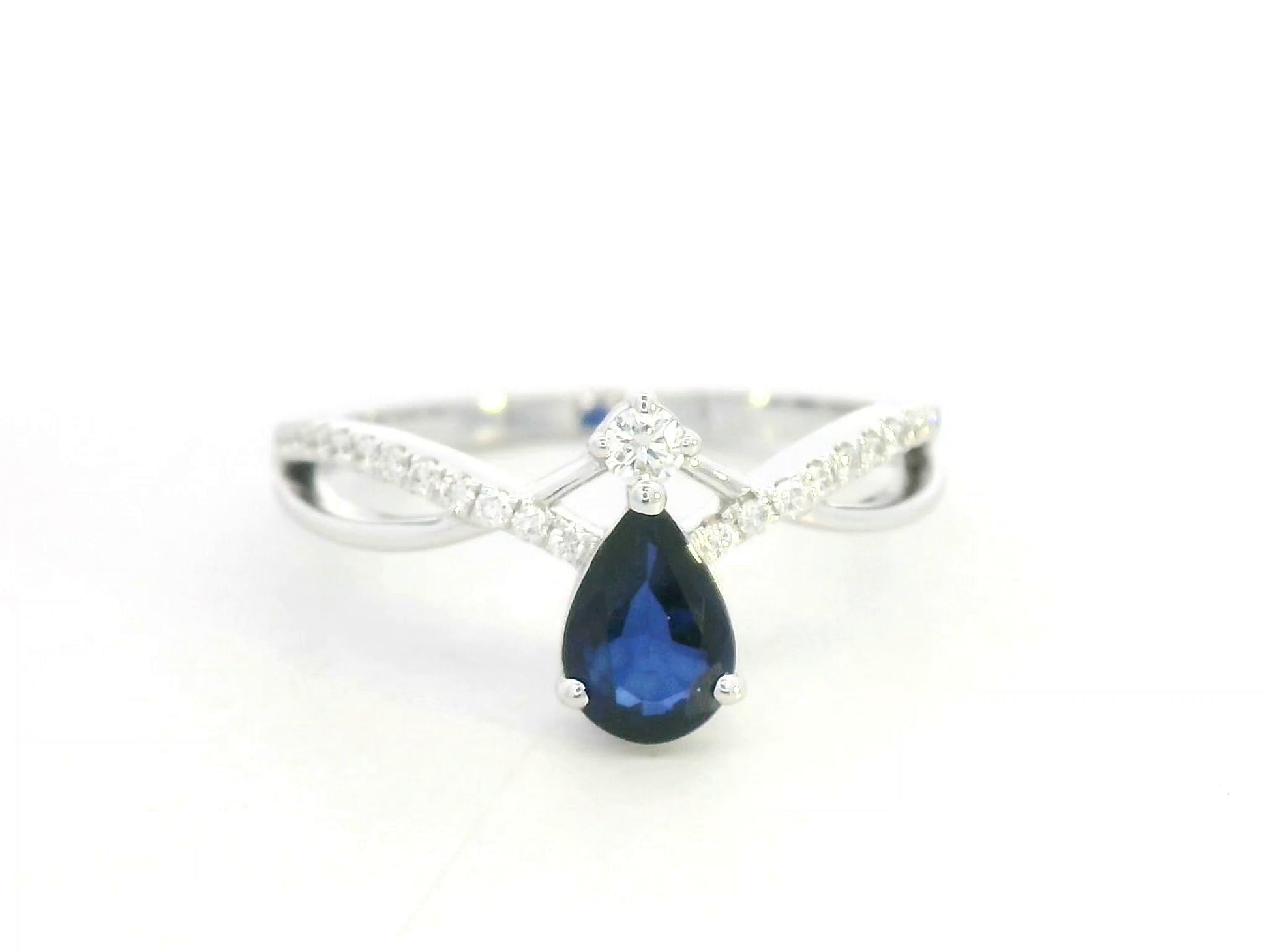 18K white gold blue sapphire and diamond crossover band ring, pear-shaped sapphire with pavé diamond accents by Emirates Diamonds