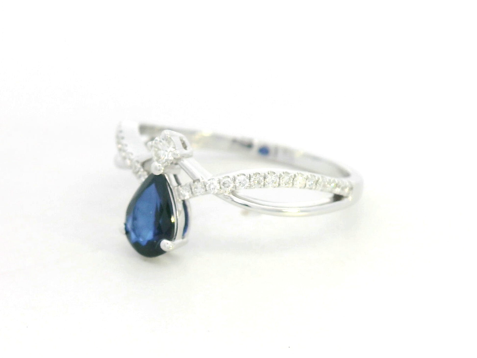 18K white gold blue sapphire and diamond crossover band ring, pear-shaped sapphire with pavé diamond accents by Emirates Diamonds