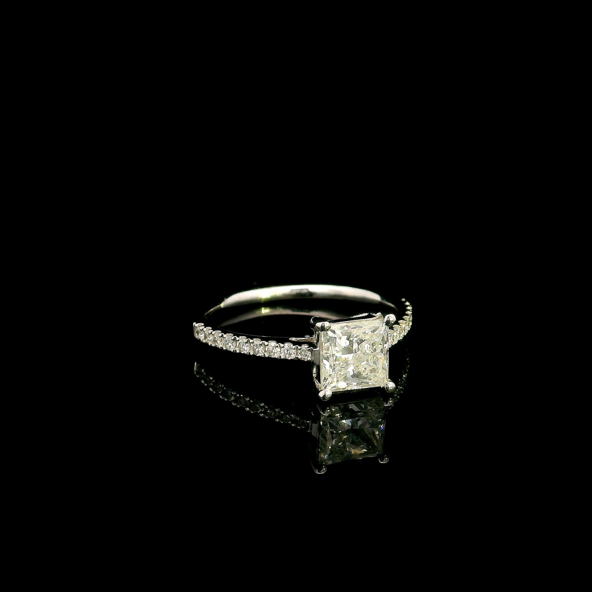 18K white gold engagement ring featuring a 1.50 carat IGI certified natural princess cut diamond with G color and SI2 clarity, accented by 0.20 carat natural round brilliant diamonds on the band.