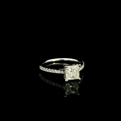 18K white gold engagement ring featuring a 1.50 carat IGI certified natural princess cut diamond with G color and SI2 clarity, accented by 0.20 carat natural round brilliant diamonds on the band.