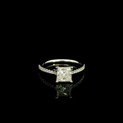 18K white gold engagement ring featuring a 1.50 carat IGI certified natural princess cut diamond with G color and SI2 clarity, accented by 0.20 carat natural round brilliant diamonds on the band.