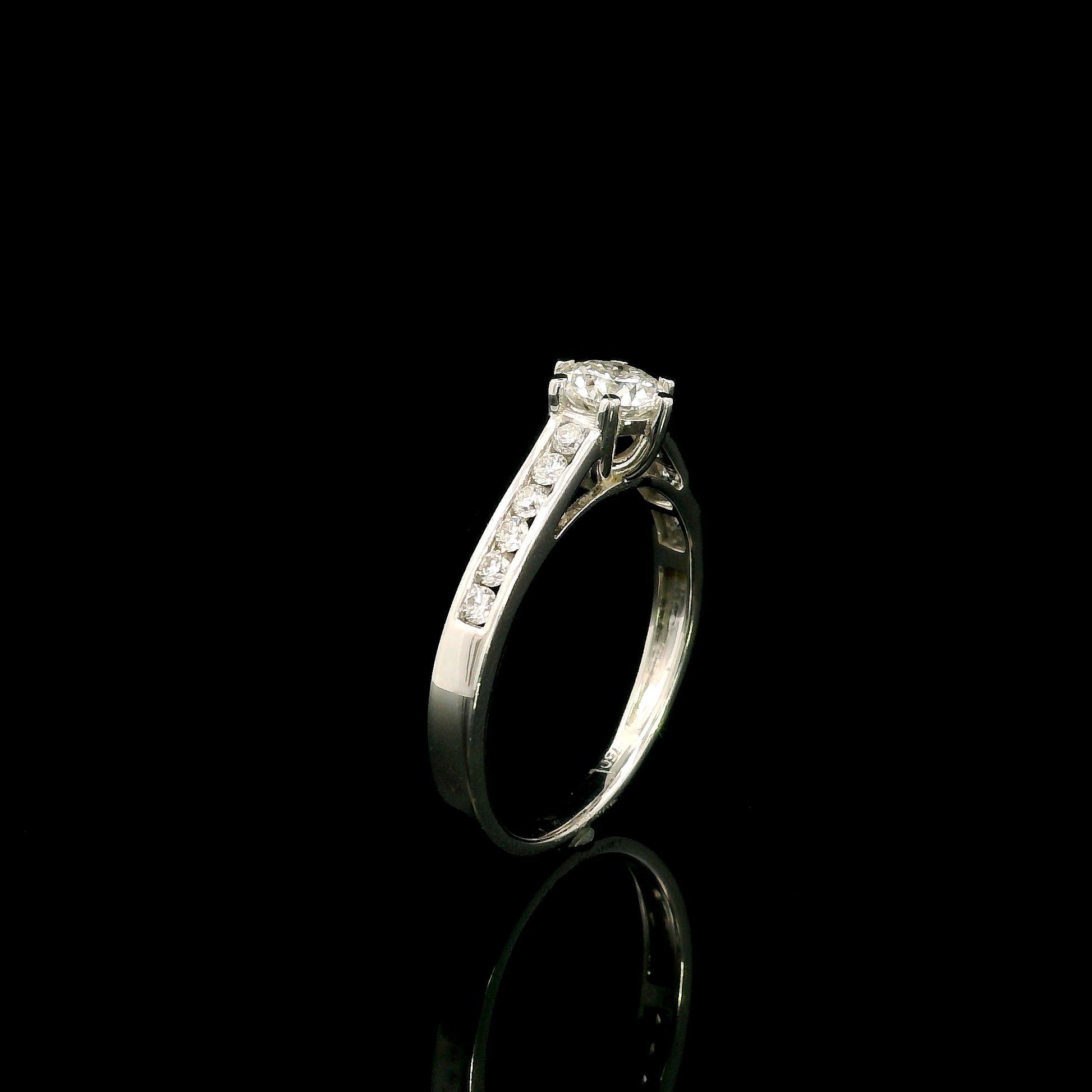 18K white gold engagement ring featuring a 0.60 carat GIA certified natural round brilliant diamond with F color and SI2 clarity, accented by 0.25 carat natural round diamonds on the shoulders in a classic six-prong setting.