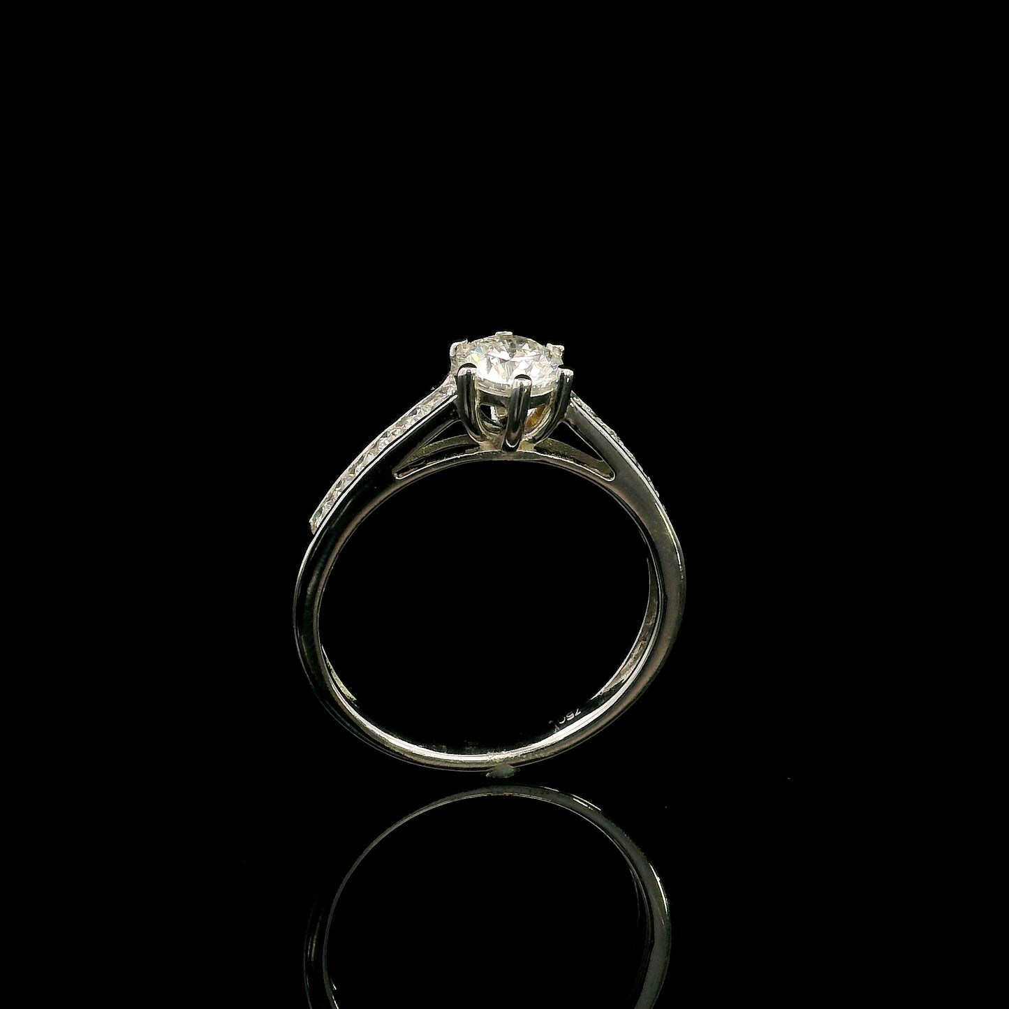 18K white gold engagement ring featuring a 0.60 carat GIA certified natural round brilliant diamond with F color and SI2 clarity, accented by 0.25 carat natural round diamonds on the shoulders in a classic six-prong setting.