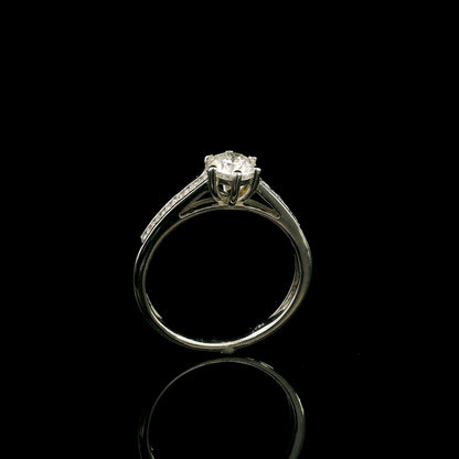 18K white gold engagement ring featuring a 0.60 carat GIA certified natural round brilliant diamond with F color and SI2 clarity, accented by 0.25 carat natural round diamonds on the shoulders in a classic six-prong setting.