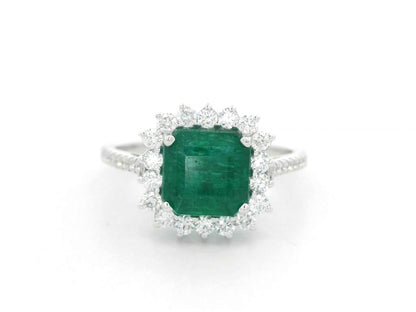 Emerald and diamond halo ring in 18K white gold featuring a 2.12 carat emerald and pavé diamond band by Emirates Diamonds