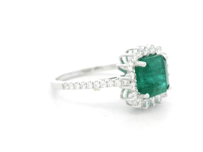 Emerald and diamond halo ring in 18K white gold featuring a 2.12 carat emerald and pavé diamond band by Emirates Diamonds