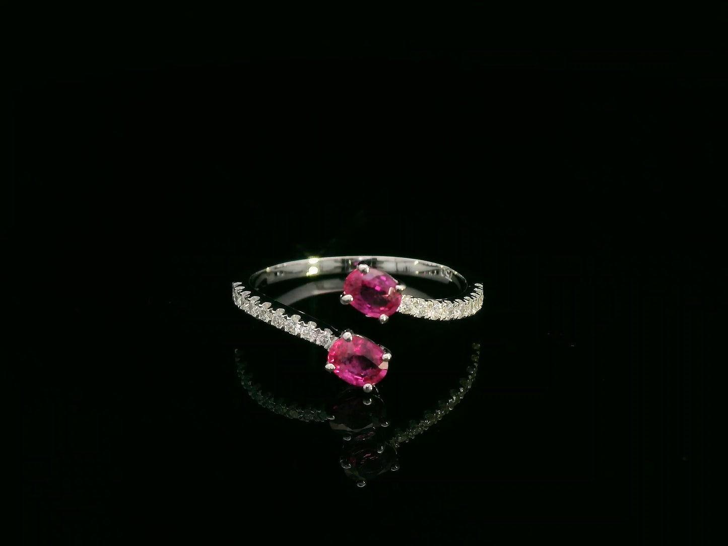 18K white gold open bypass ring with oval ruby gemstones and pavé diamond accents – fine ruby and diamond jewelry by Emirates Diamonds.