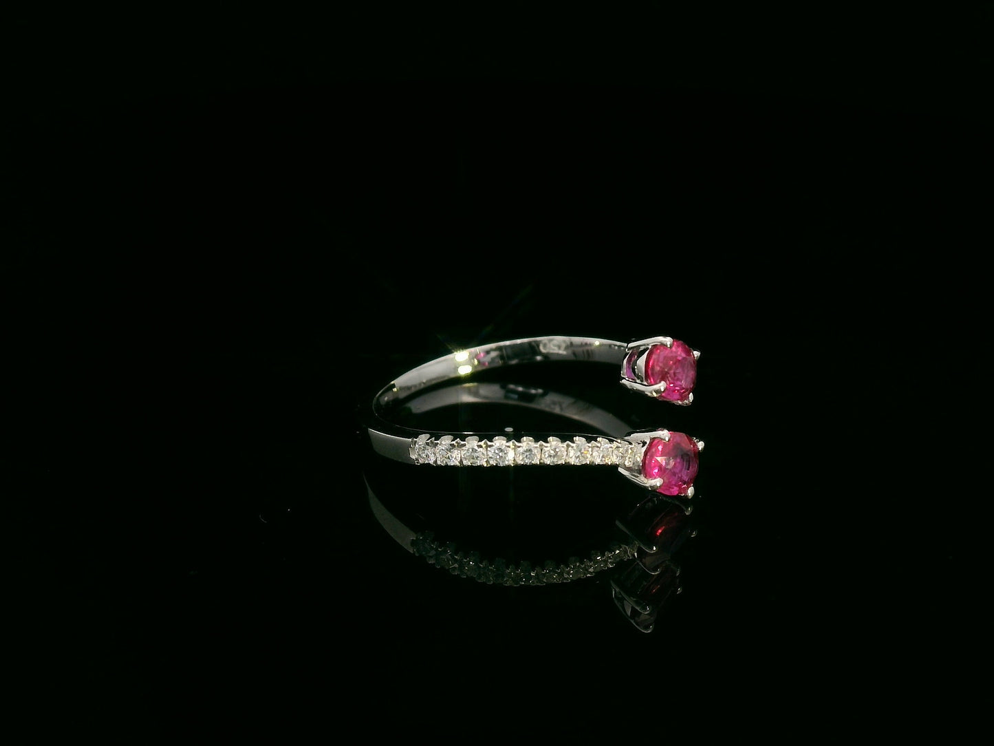 18K white gold open bypass ring with oval ruby gemstones and pavé diamond accents – fine ruby and diamond jewelry by Emirates Diamonds.