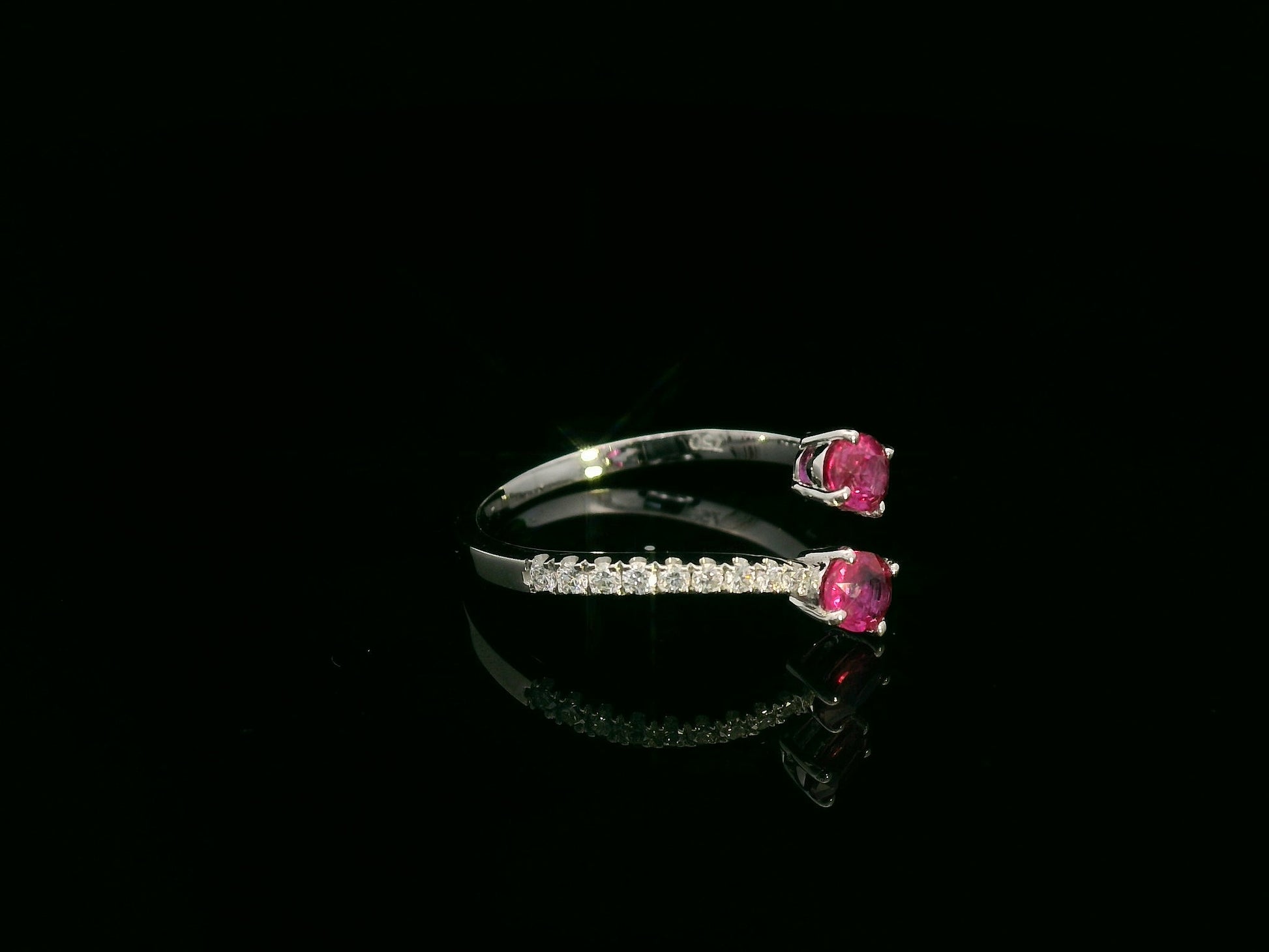 18K white gold open bypass ring with oval ruby gemstones and pavé diamond accents – fine ruby and diamond jewelry by Emirates Diamonds.