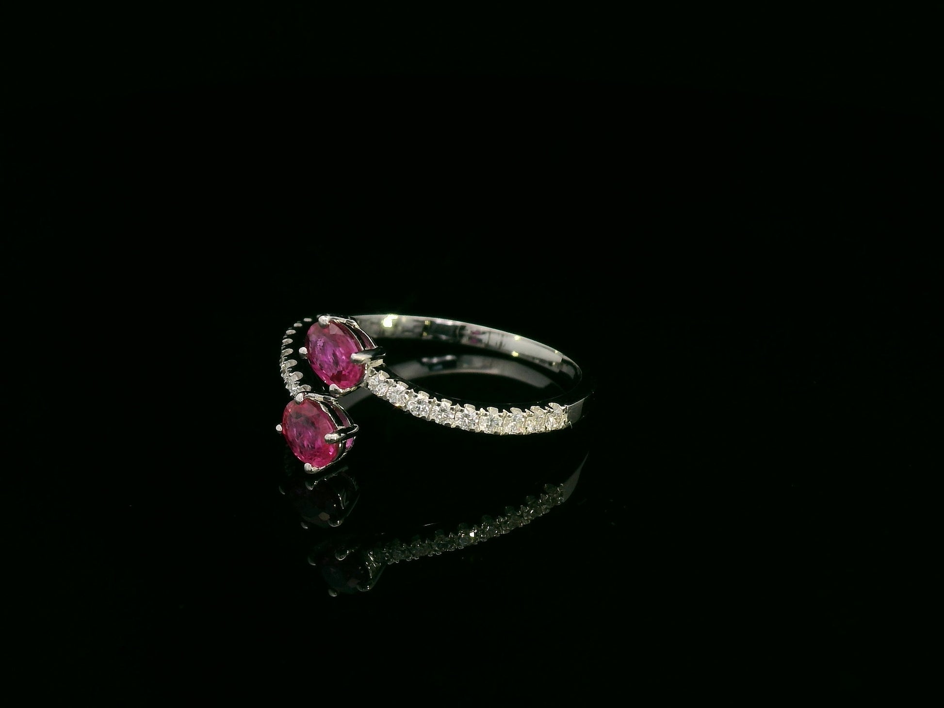 18K white gold open bypass ring with oval ruby gemstones and pavé diamond accents – fine ruby and diamond jewelry by Emirates Diamonds.