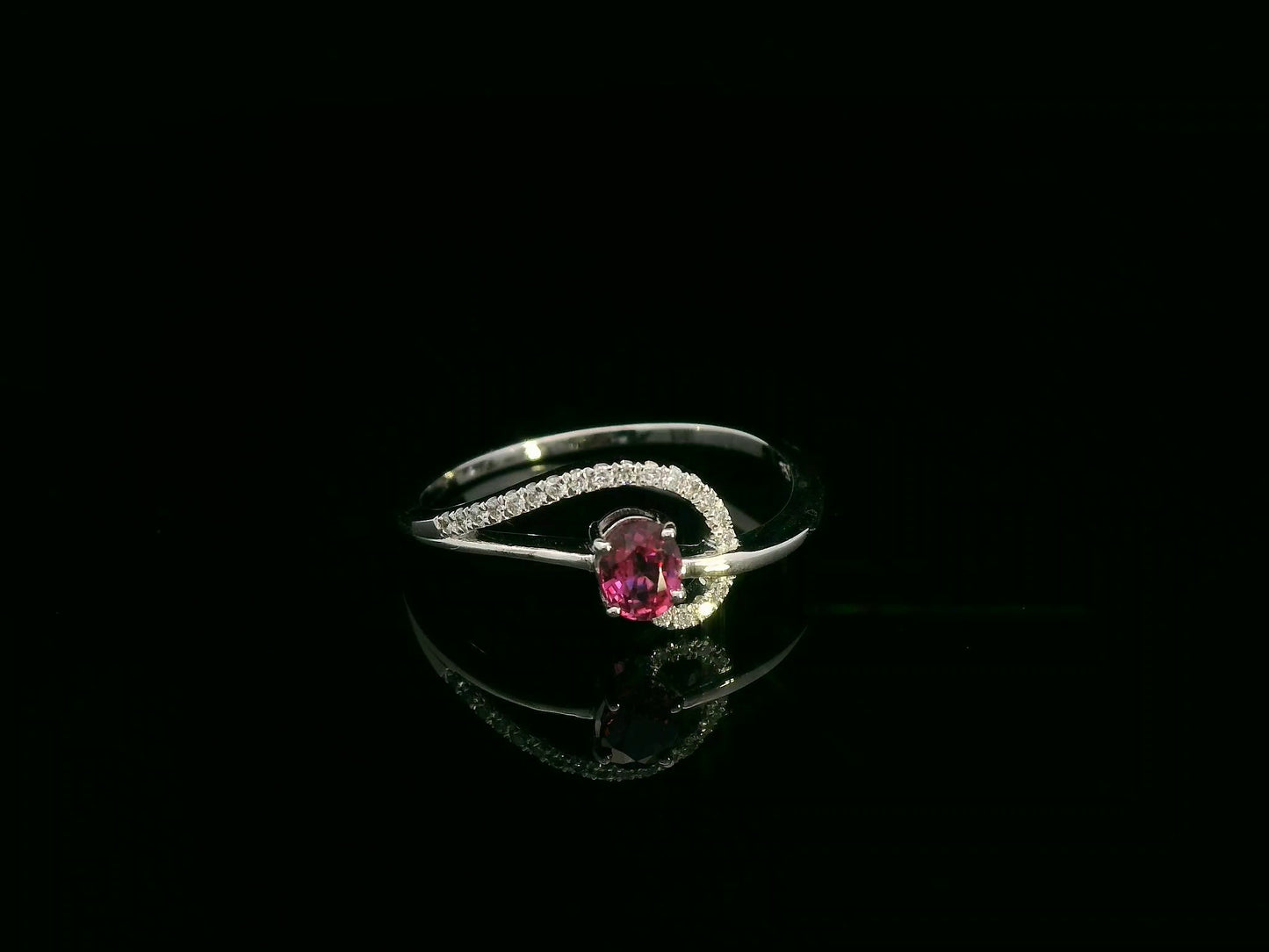 18K white gold ruby and diamond curved ring with oval ruby and flowing diamond-accented band by Emirates Diamonds