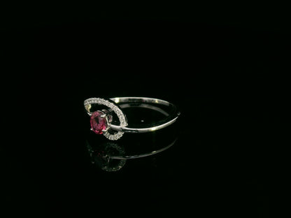 18K white gold ruby and diamond curved ring with oval ruby and flowing diamond-accented band by Emirates Diamonds