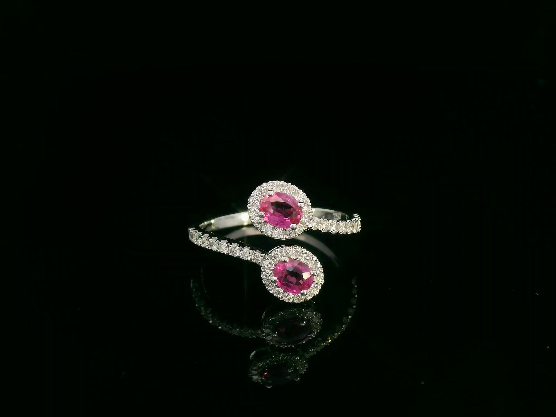 18K white gold ruby and diamond bypass ring with dual oval rubies and diamond halos by Emirates Diamonds