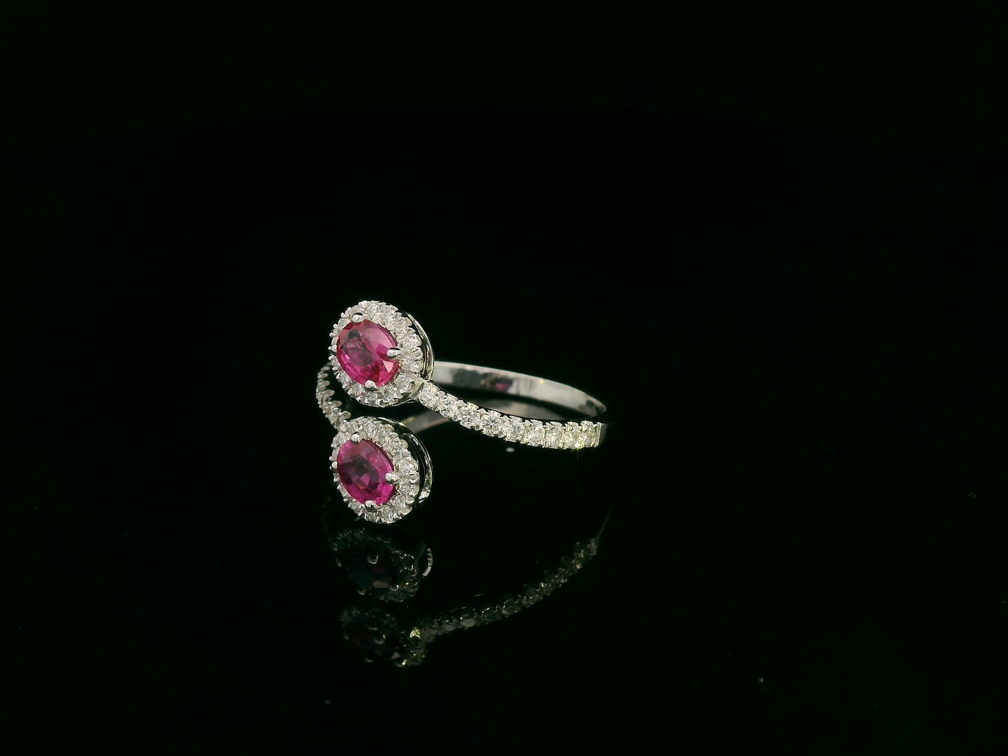 18K white gold ruby and diamond bypass ring with dual oval rubies and diamond halos by Emirates Diamonds