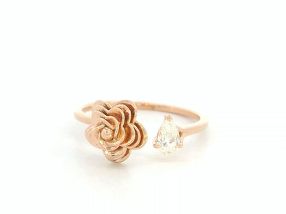 18K rose gold bypass ring featuring a 0.18 carat pear-cut diamond with sculpted floral gold detail – Emirates Diamonds