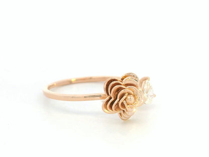 18K rose gold bypass ring featuring a 0.18 carat pear-cut diamond with sculpted floral gold detail – Emirates Diamonds