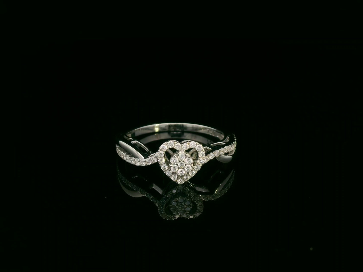 Heart-shaped diamond cluster ring in 18K white gold with pavé diamond band by Emirates Diamonds.