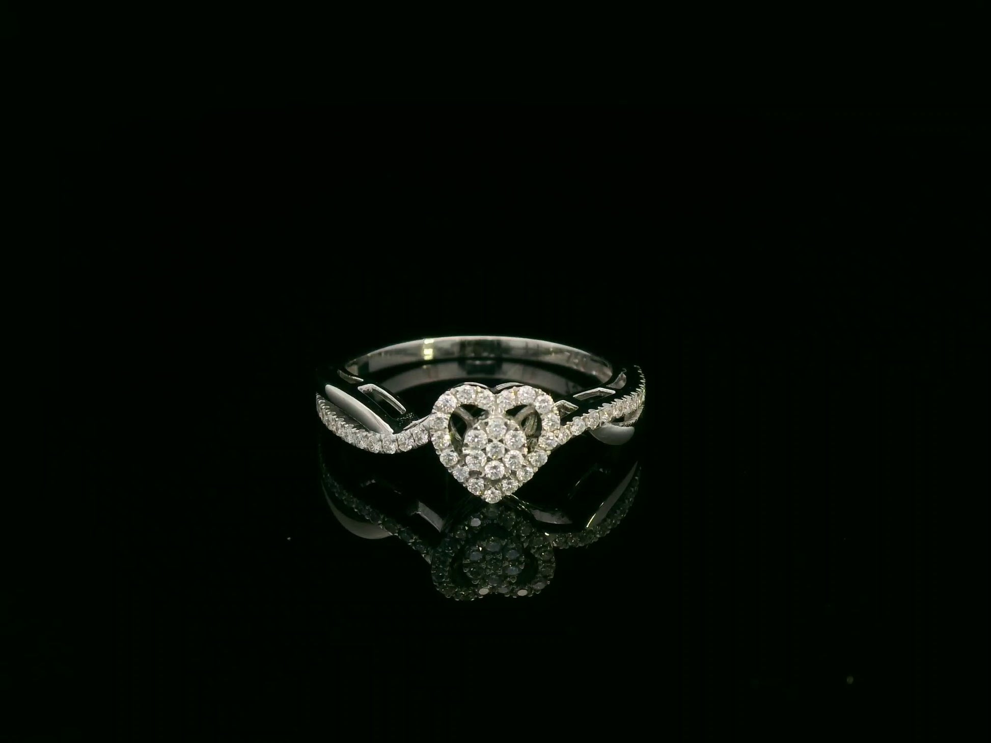 Heart-shaped diamond cluster ring in 18K white gold with pavé diamond band by Emirates Diamonds.