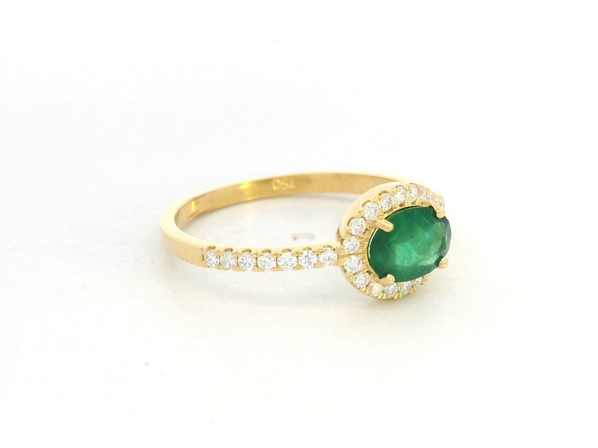 18K yellow gold ring featuring 0.59 carat oval emerald with 0.21 carat diamond accents by Emirates Diamonds.