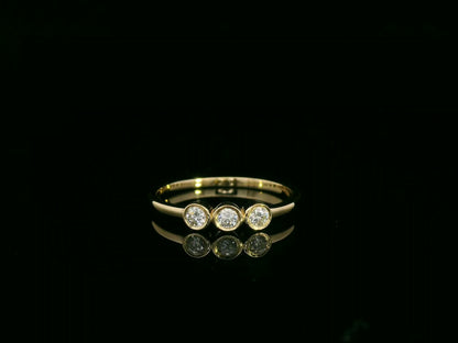 18K yellow gold three-stone natural diamond ring with minimalist bezel setting by Emirates Diamonds