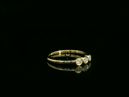 18K yellow gold three-stone natural diamond ring with minimalist bezel setting by Emirates Diamonds